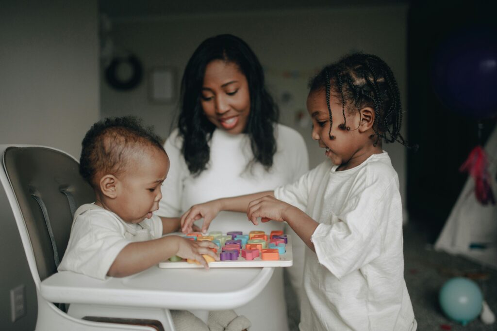 A happy family moment with children playing together at home with colorful blocks.